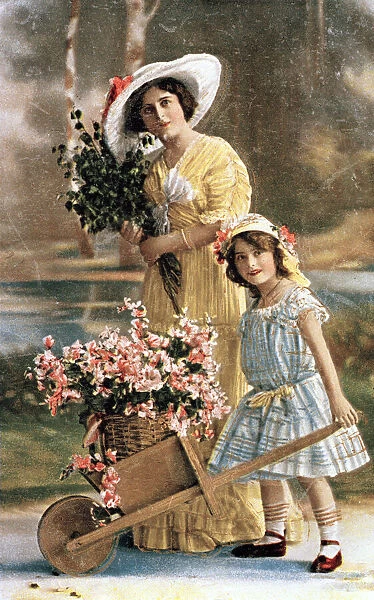 Woman and girl with flowers in a wheelbarrow