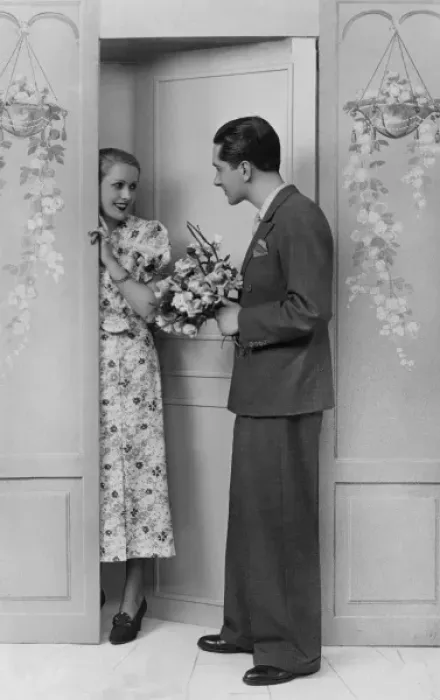 Framed Print : Woman greets her sweetheart who stands at door with flowers Framed Print : Woman greets her sweetheart who stands at door with flowers