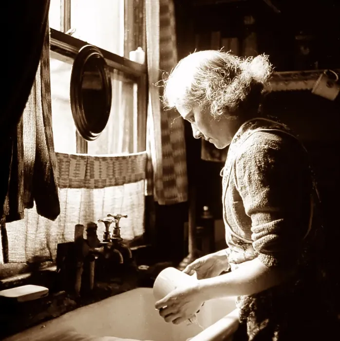 Framed Print : Woman at a kitchen sink, probably 1930s Framed Print : Woman at a kitchen sink, probably 1930s