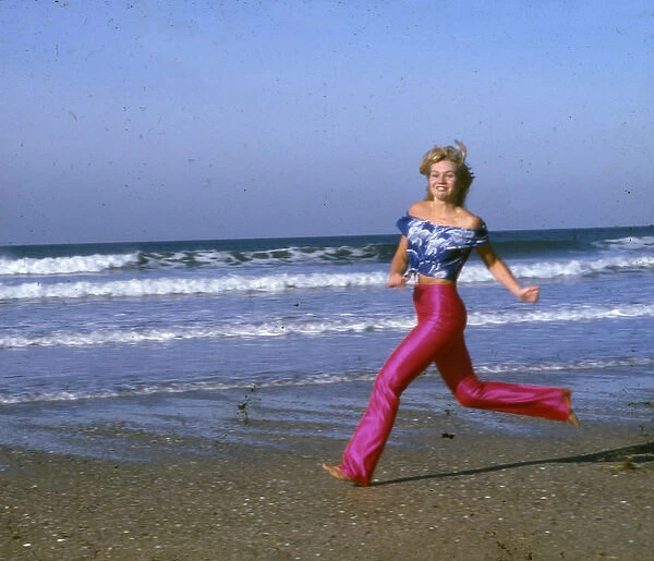 Woman running on a beach, Cornwall