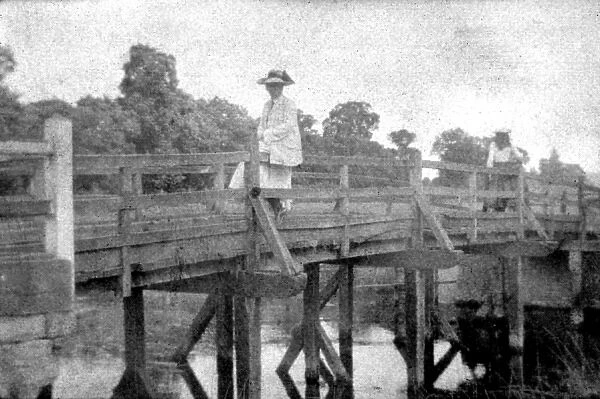Woman seated on bridge