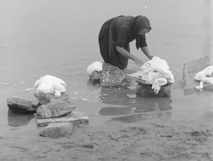 Framed Print : Woman sorting out washing in a river Framed Print : Woman sorting out washing in a river