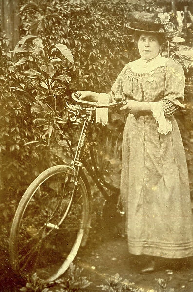Woman standing in a garden with her bicycle