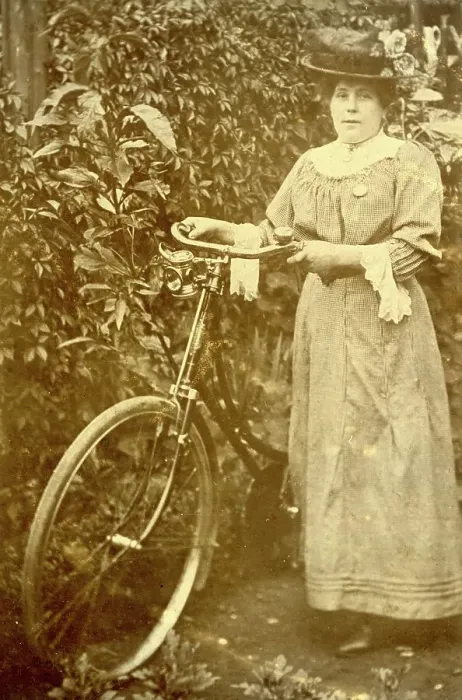 Framed Print : Woman standing in a garden with her bicycle