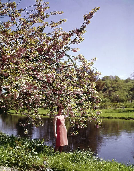 Woman standing by a river in springtime