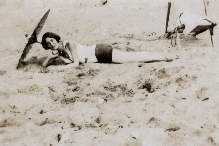 Framed Print : Woman sunbathing underneath a parasol on the beach Framed Print : Woman sunbathing underneath a parasol on the beach