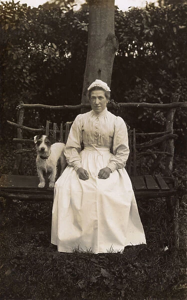 Woman with terrier on a bench in a garden
