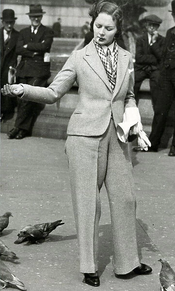 Woman in trouser suit feeding pigeons, Trafalgar Square