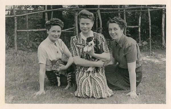 Three women with cat and puppy in a garden