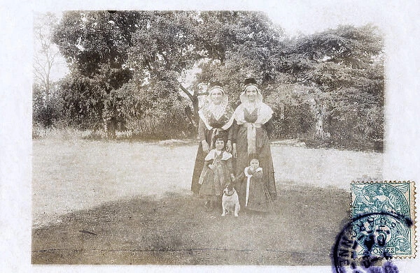 Two women and two children in a garden, with a dog