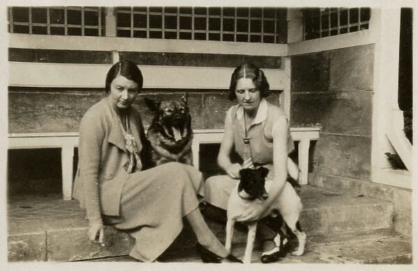 Two women with dogs in a back garden