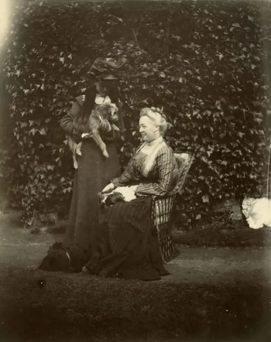 Framed Print : Two women with two dogs in a garden Framed Print : Two women with two dogs in a garden