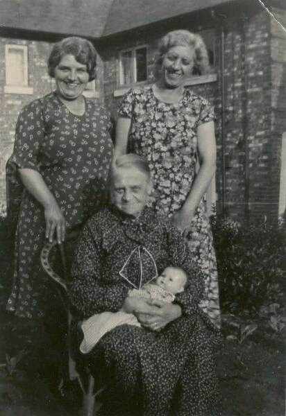 Three women in back garden with doll