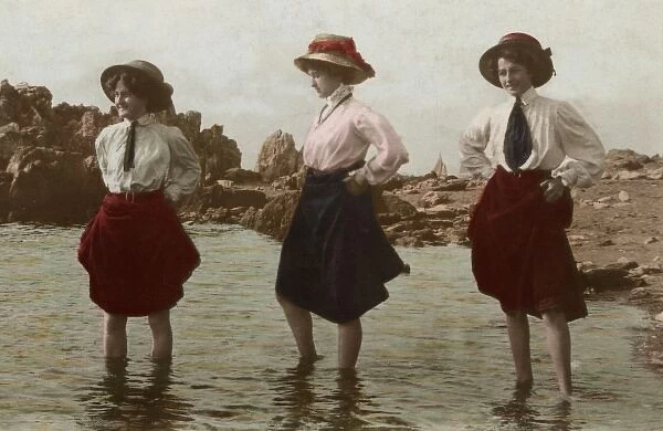 Three women go paddling at the seaside