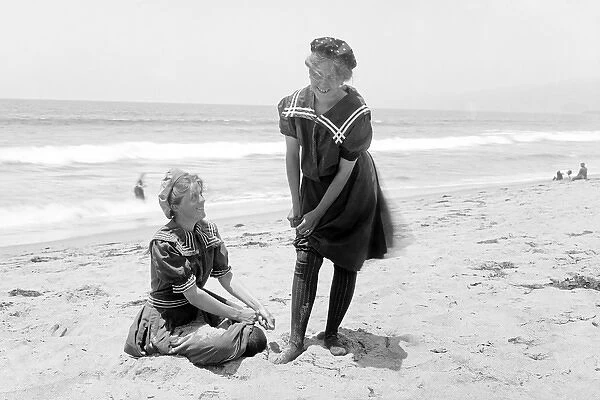 Two women in period bathing suits on the beach in America