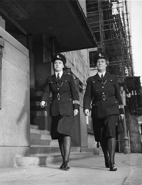 Two women police officers walking along London street
