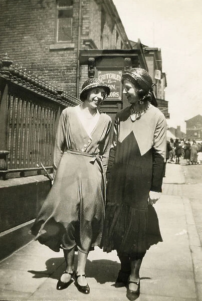 Two women walking together along a street