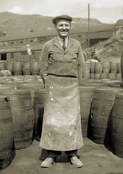 Workman in apron with barrels