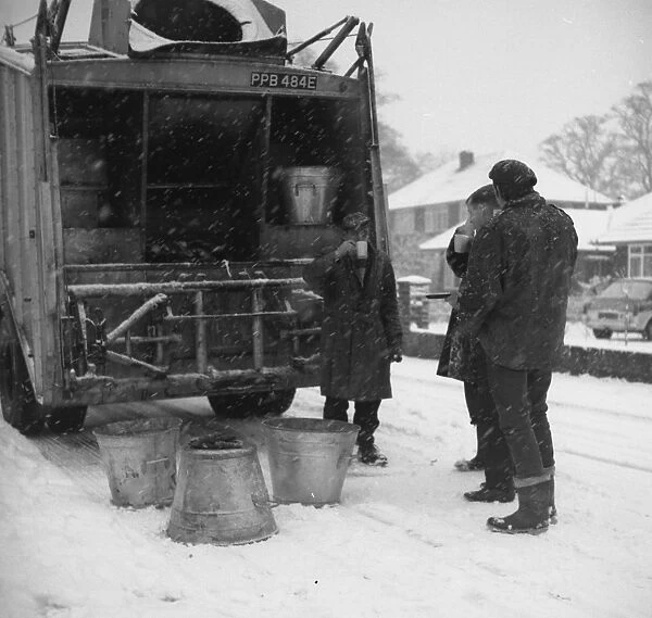 Three workmen stop for a cup of tea on a snowy day