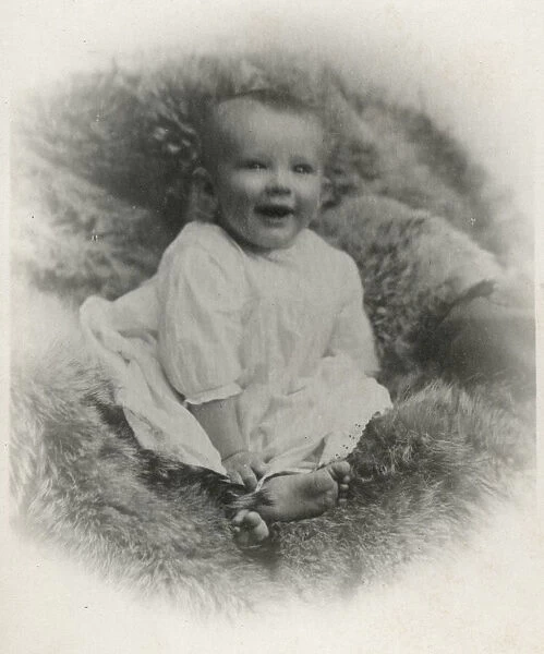 A young baby on a fur-covered seat