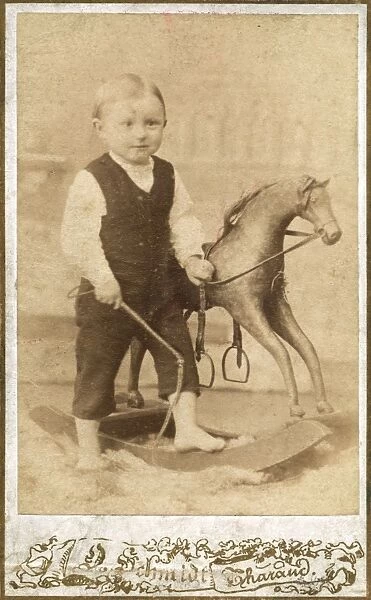 Young German boy with rocking horse and whip