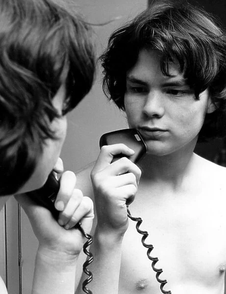 Young lad using an electric razor