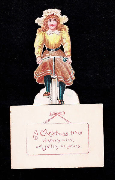 Young woman on a bicycle on a cutout Christmas card