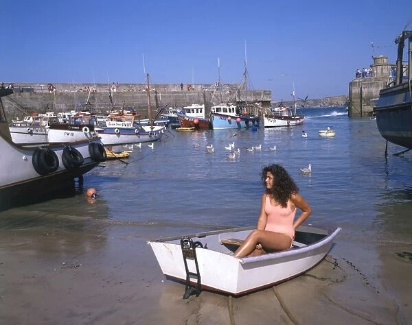 Young woman in a boat at Newquay harbour, Cornwall