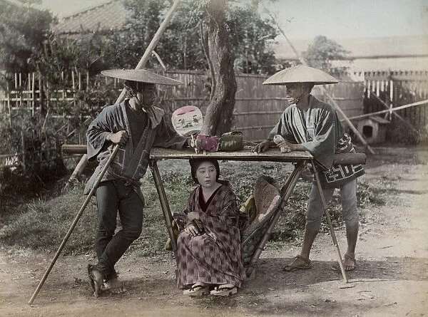 Young woman in carrying chair, kago, Japan, with porters