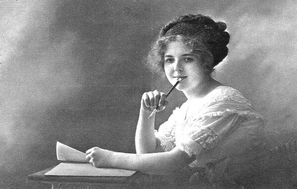 Young woman at desk writing letter