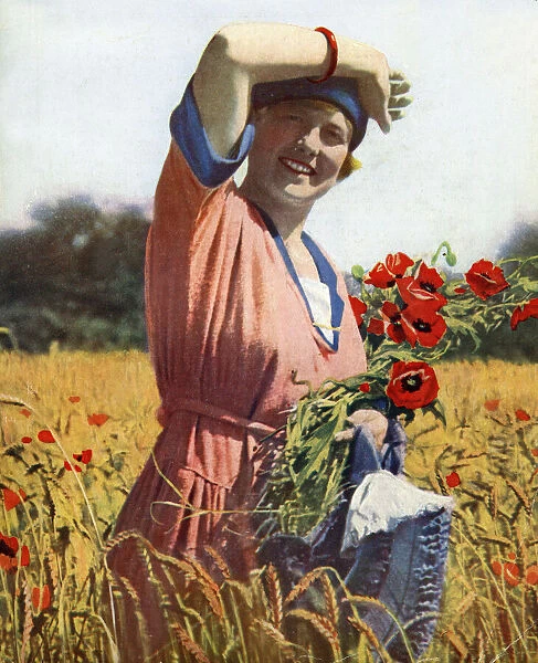 Young woman in a field of poppies, England