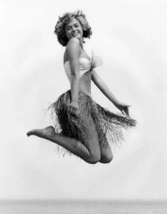Framed Print : Young woman jumping in a grass skirt, West Country Framed Print : Young woman jumping in a grass skirt, West Country