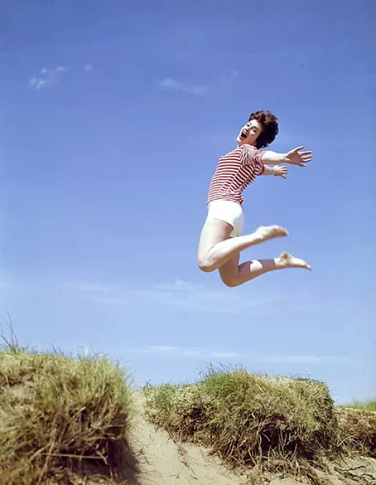 Framed Print : Young woman leaps up from a sand dune Framed Print : Young woman leaps up from a sand dune