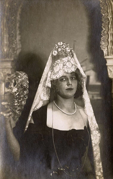 Young woman in a Spanish mantilla, holding a fan