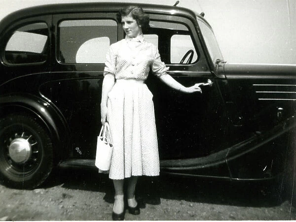 Young woman standing by a car