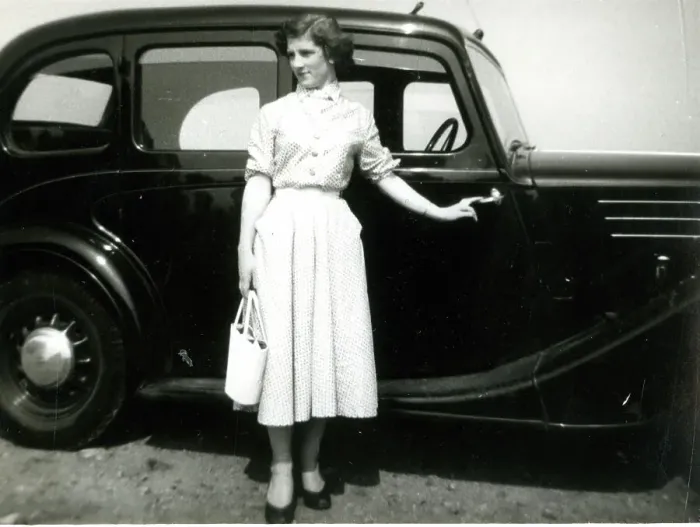 Framed Print : Young woman standing by a car Framed Print : Young woman standing by a car
