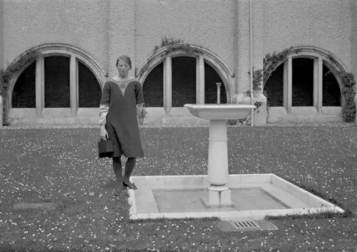 Framed Print : Young woman standing by a fountain Framed Print : Young woman standing by a fountain