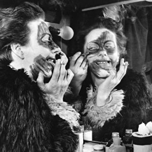 Actress Freda Wyn doing cat makeup for a pantomime
