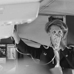 Air stewardess demonstrating oxygen mask