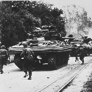 Amphibious tanks moving through a town, June 1944