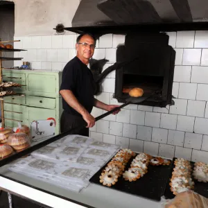 Baker Juan Olives bakes bread in olive wood burning oven