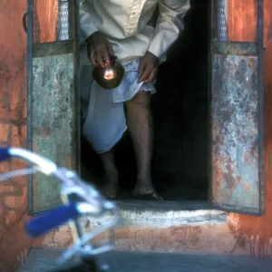 A bald man comes through a small door in a shrine in Jaipur