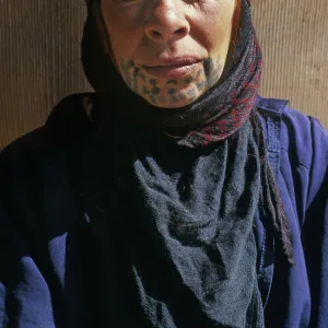 Bedouin woman with face tattoos outside her tent, Syria