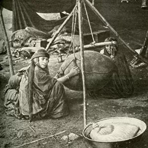 Bedouin women making butter in a goatskin, Arabia