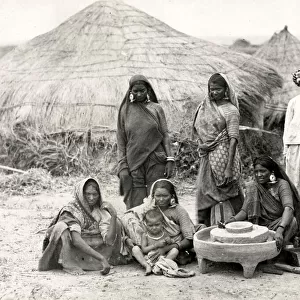 Bheel or Bhil women grinding corn, India