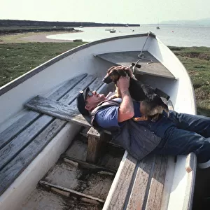 Boatman and dog on the saltings at Askam, near Barrow