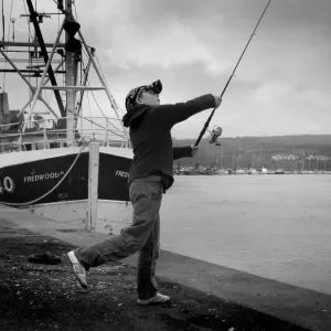 Boy casts his fishing line into River Dee at Kirkcudbright Boy casts his fishing line into River Dee at Kirkcudbright