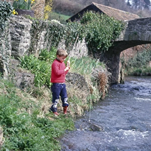 Boy fishing in a stream, Allerford, Somerset