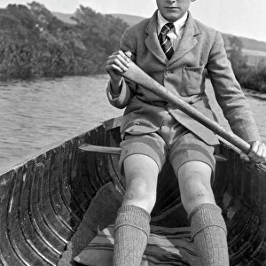 Boy in school uniform rowing a boat