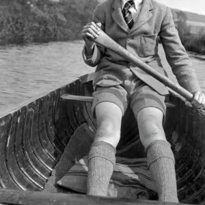 Boy in school uniform rowing a boat